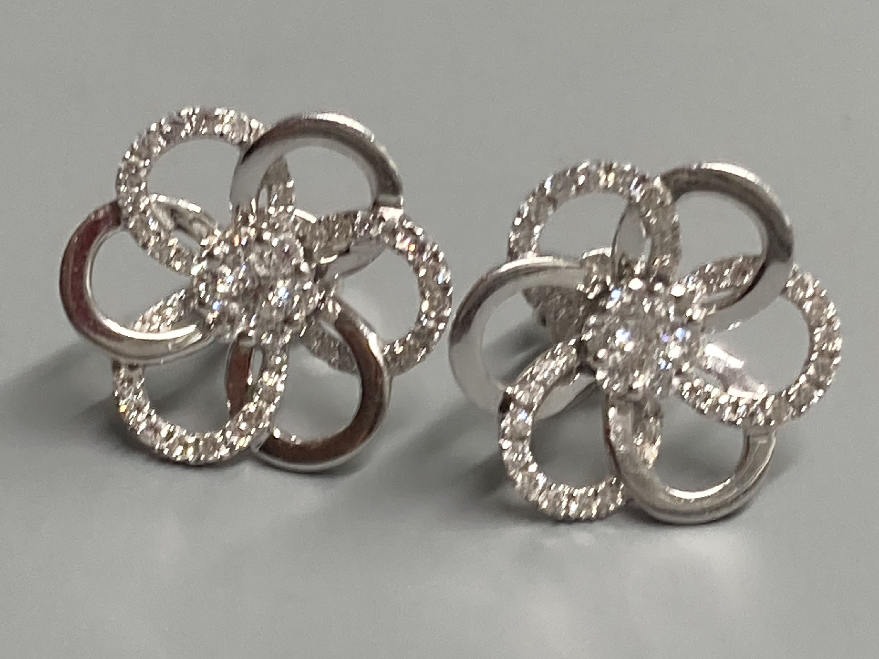 A modern pair of 18ct white gold and diamond cluster set openwork flower head ear studs, diameter 16mm, gross weight 4.4 grams.